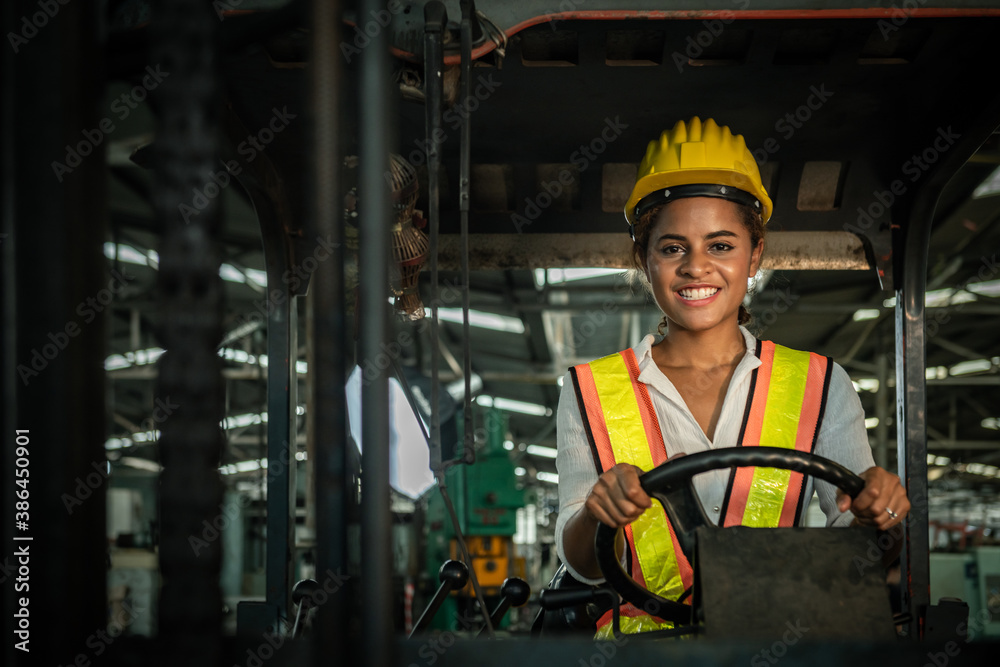 Female engineers are working on industrial machines. And wear a helmet for safety while working. Con