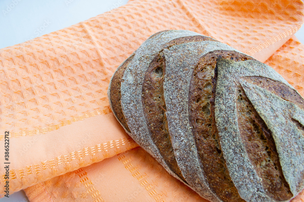 Homemade french loaf (rye bread) on an orange kitchen towel