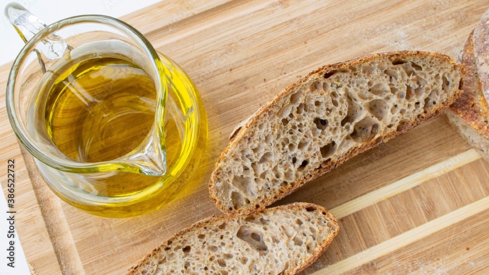 Homemade fresh bread and olive oil. On wooden board