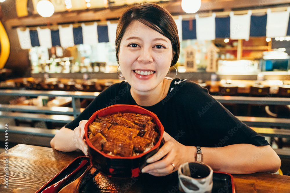 Soy sauce Japanese food to grilled eel. confident beautiful young asian chinese woman visiting izaka