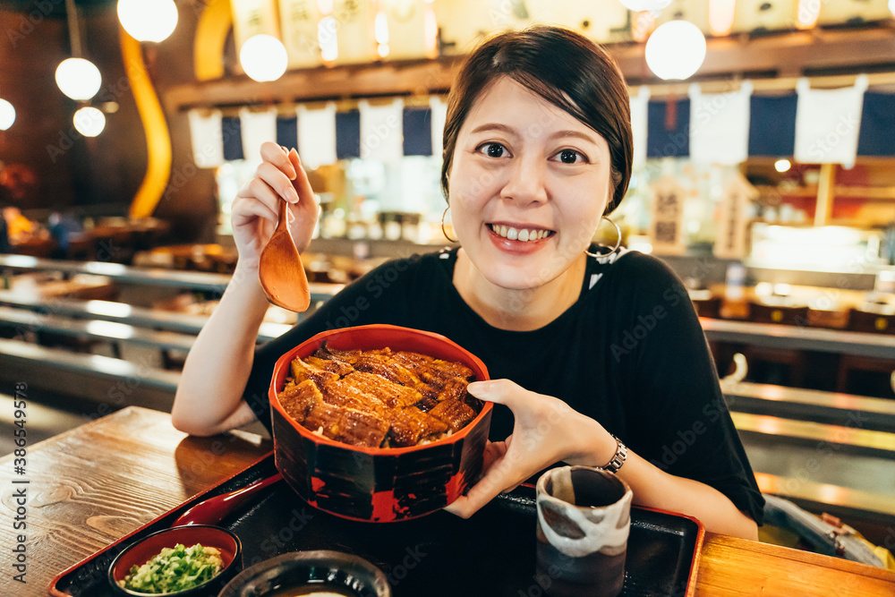 烤制日本淡水鳗鱼配Teriyaki酱汁的饭碗。年轻迷人的亚洲kor