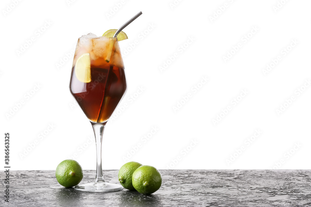 Glass of tasty Cuba Libre cocktail on table against white background