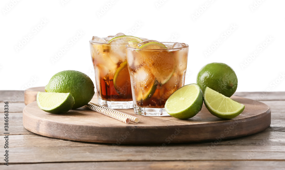 Glasses of tasty Cuba Libre cocktail on table against white background