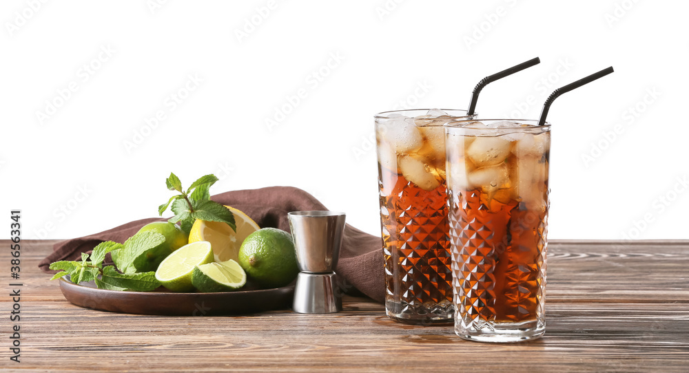 Glasses of tasty Cuba Libre cocktail on table against white background