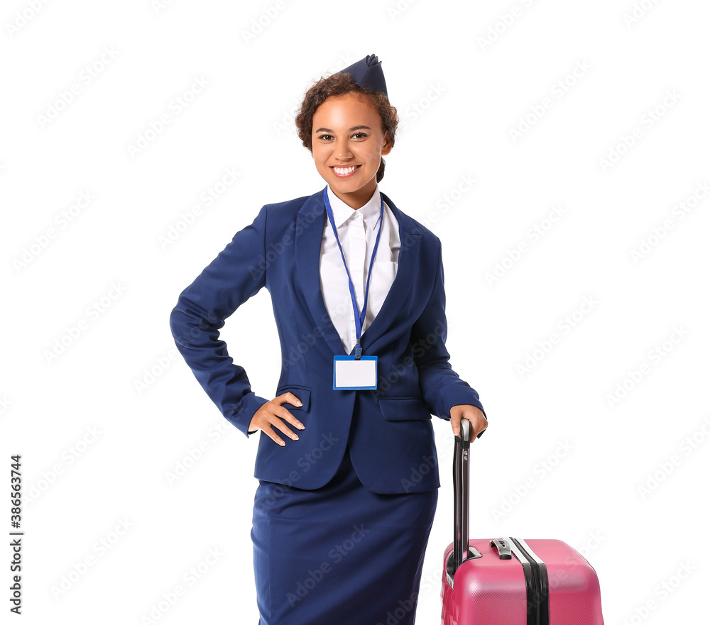 Beautiful African-American stewardess with luggage on white background