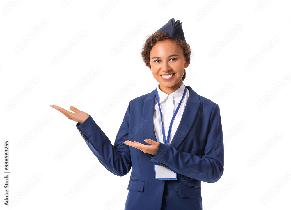 Beautiful African-American stewardess showing something on white background