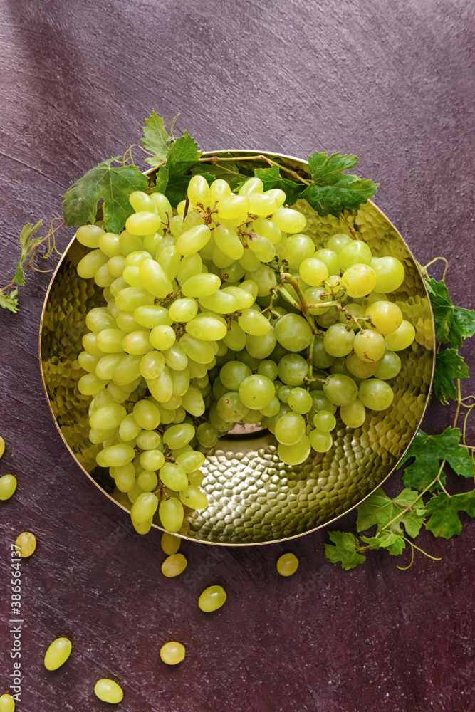 Plate with ripe grapes on table