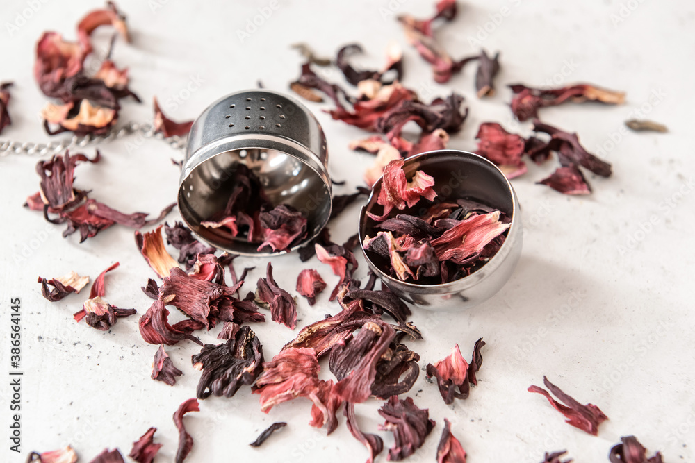 Strainer with dry hibiscus tea on table