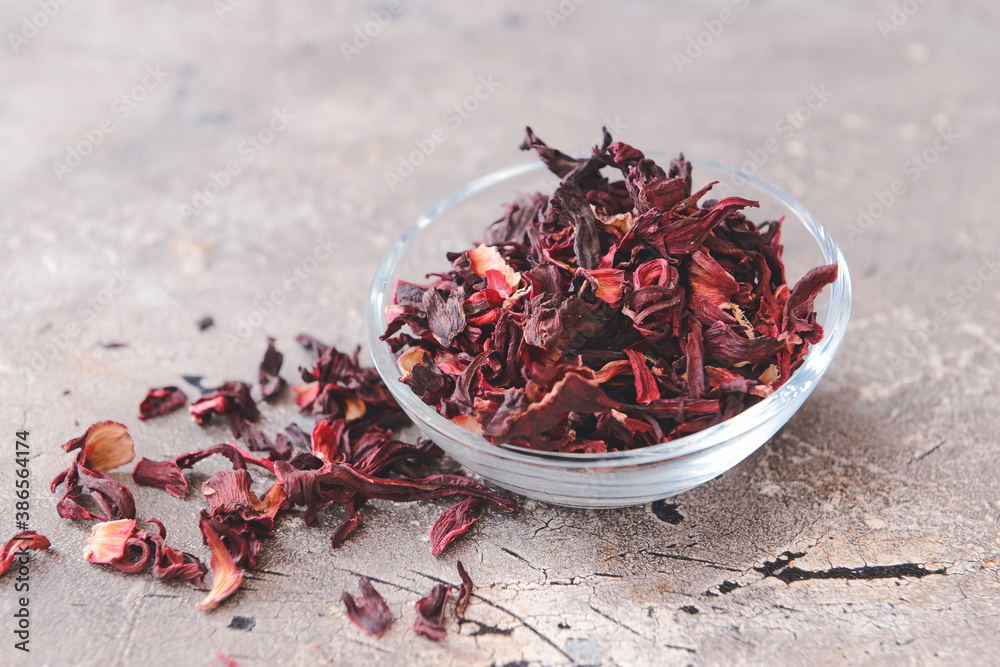 Bowl with dry hibiscus tea on table