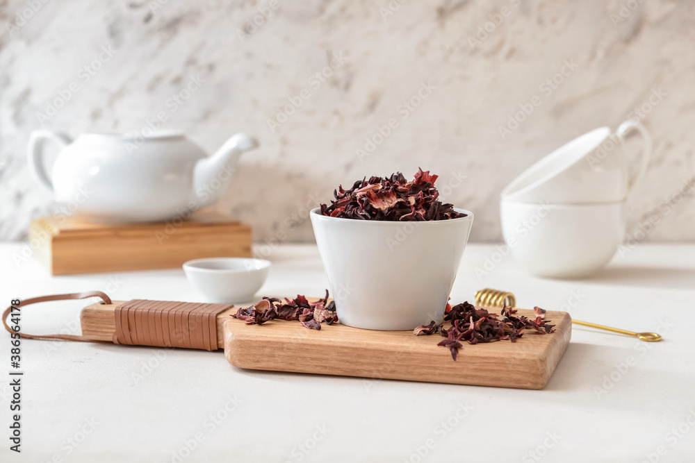 Bowl with dry hibiscus tea on table