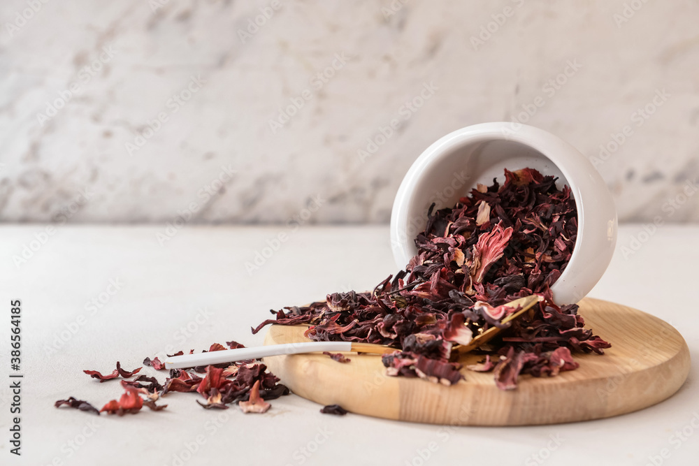 Bowl with dry hibiscus tea on table