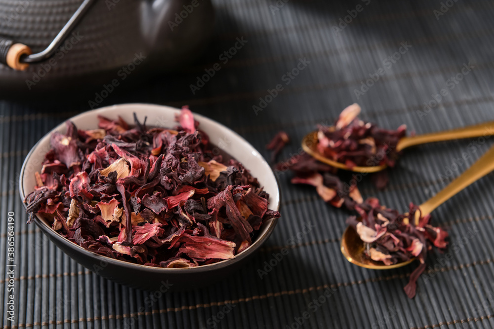 Bowl with dry hibiscus tea on table