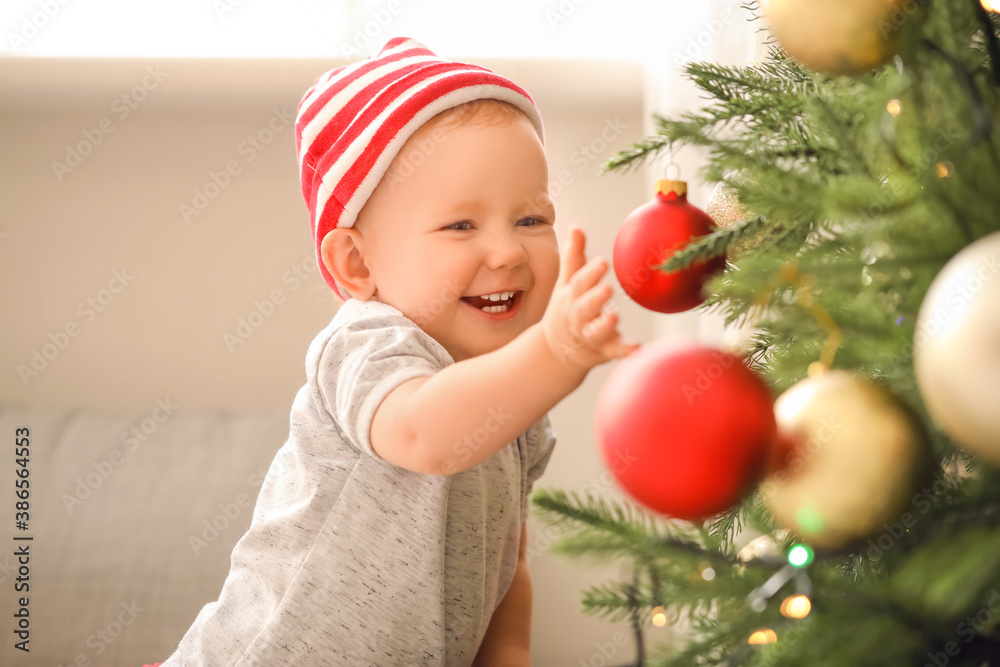 Cute little baby near Christmas tree at home