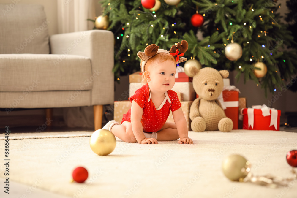 Cute little baby in room decorated for Christmas