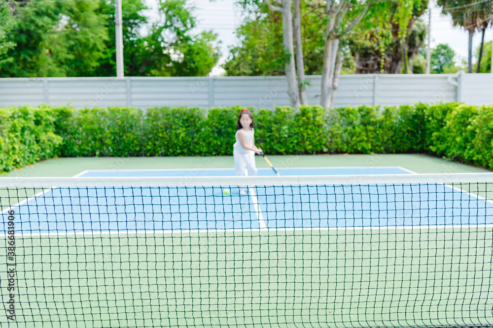 Little tennis player play tennis in court on summer.Confident asian child girl lose fist tooth with 