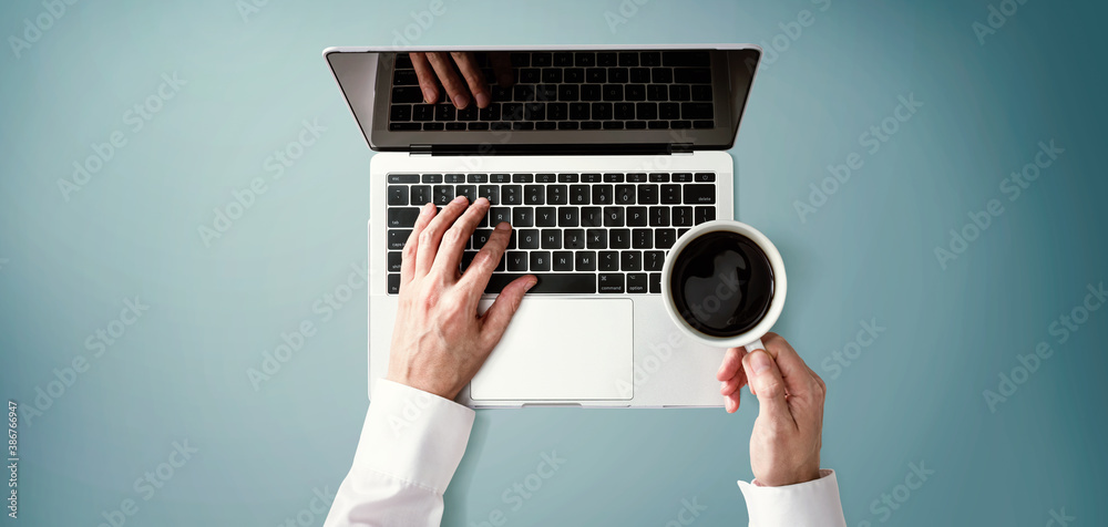 Businessman using a laptop computer overhead view