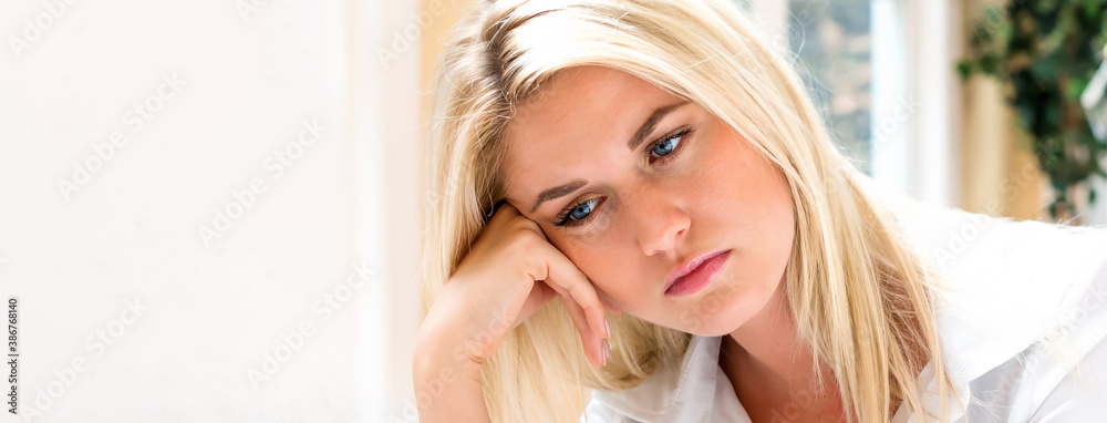 Bored young woman sitting at her desk in front of the computer