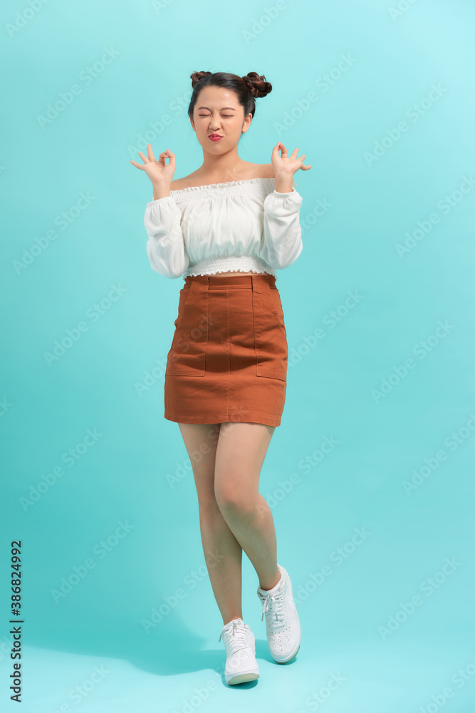 Happy emotional teen girl wearing t-shirt, jumping looking to side surprised in full length