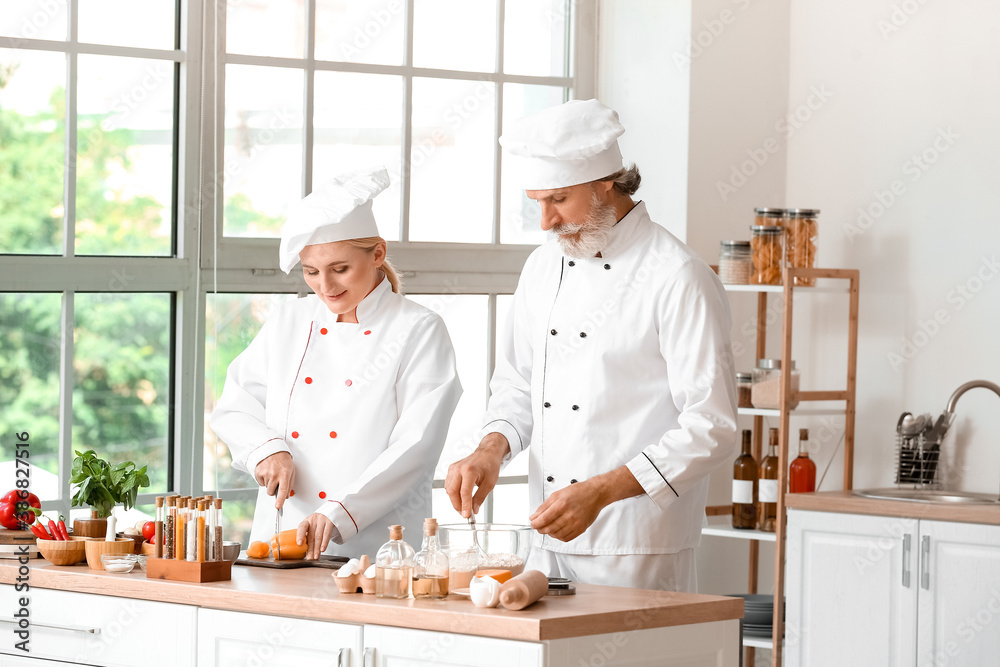 Chefs cooking tasty dish in kitchen