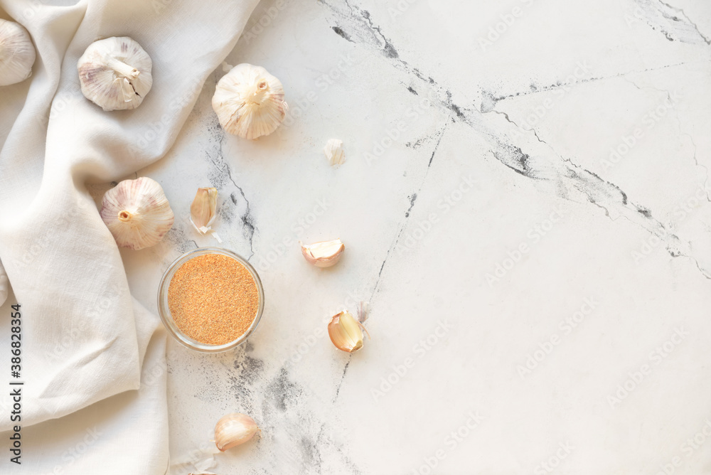 Bowl with aromatic powdered garlic on white background