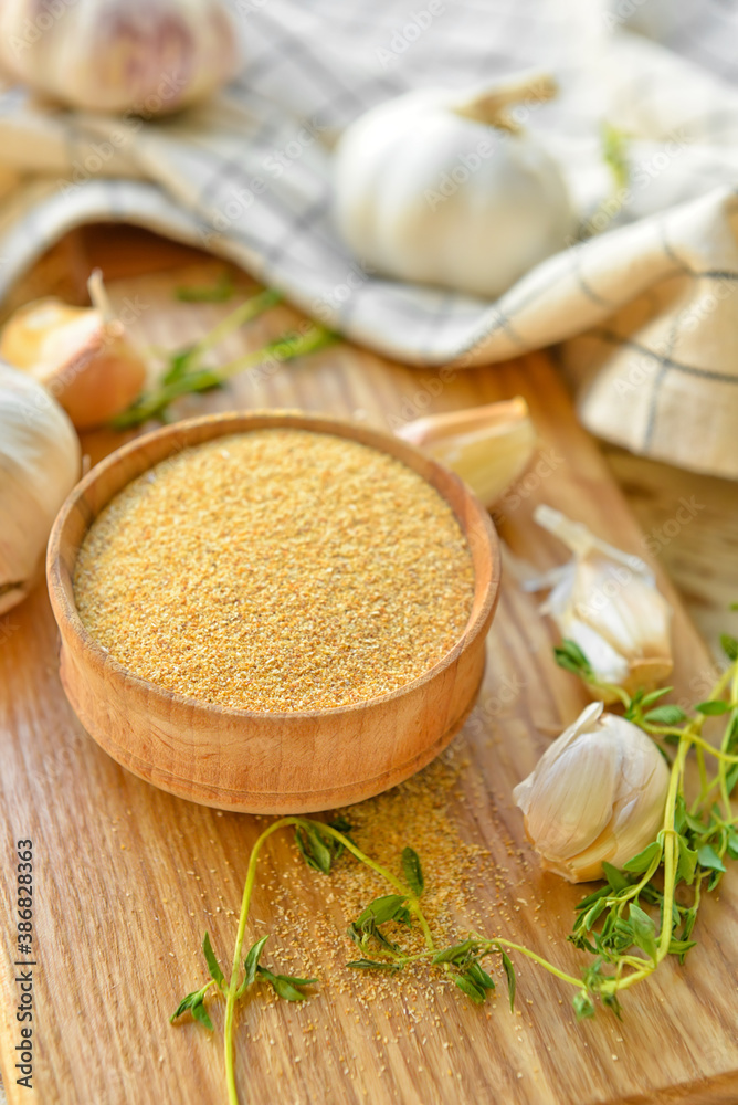 Bowl with aromatic powdered garlic on table