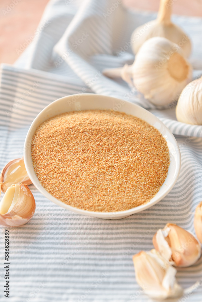 Bowl with aromatic powdered garlic on table