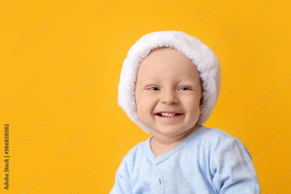 Cute little baby in Santa hat on color background