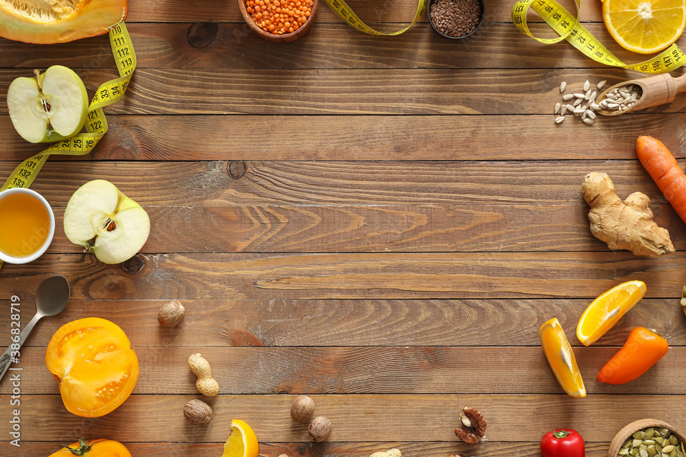 Frame made of fresh products and measuring tape on wooden background. Diet concept