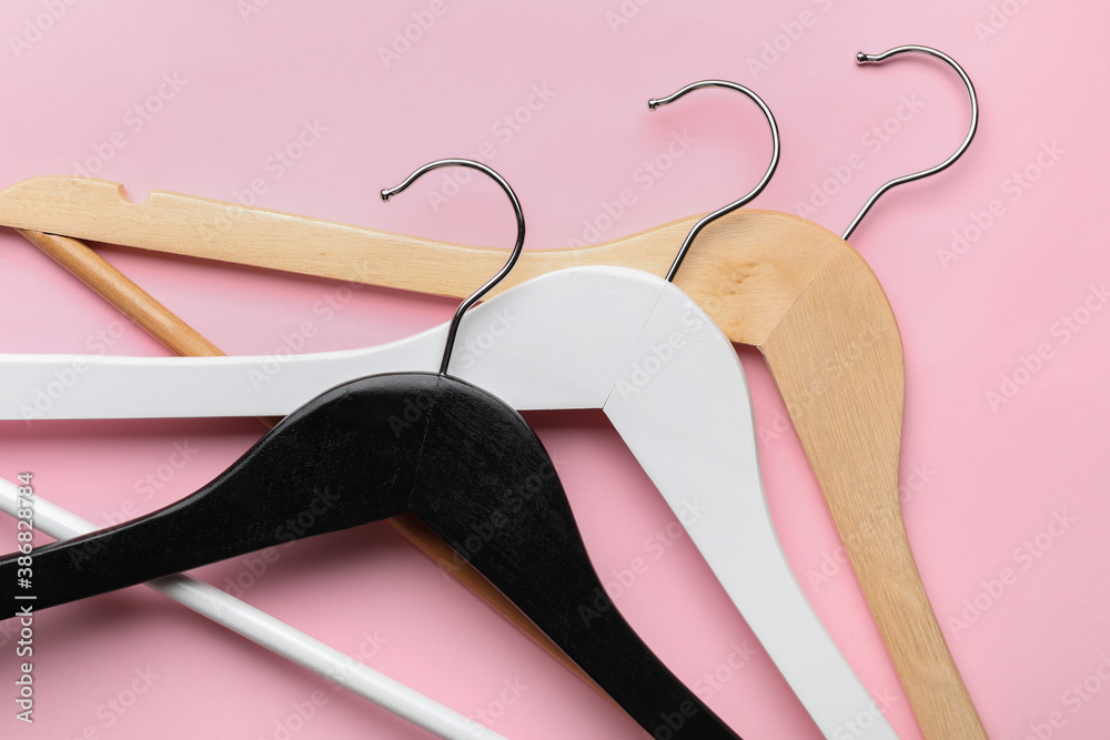 Clothes hangers on color background