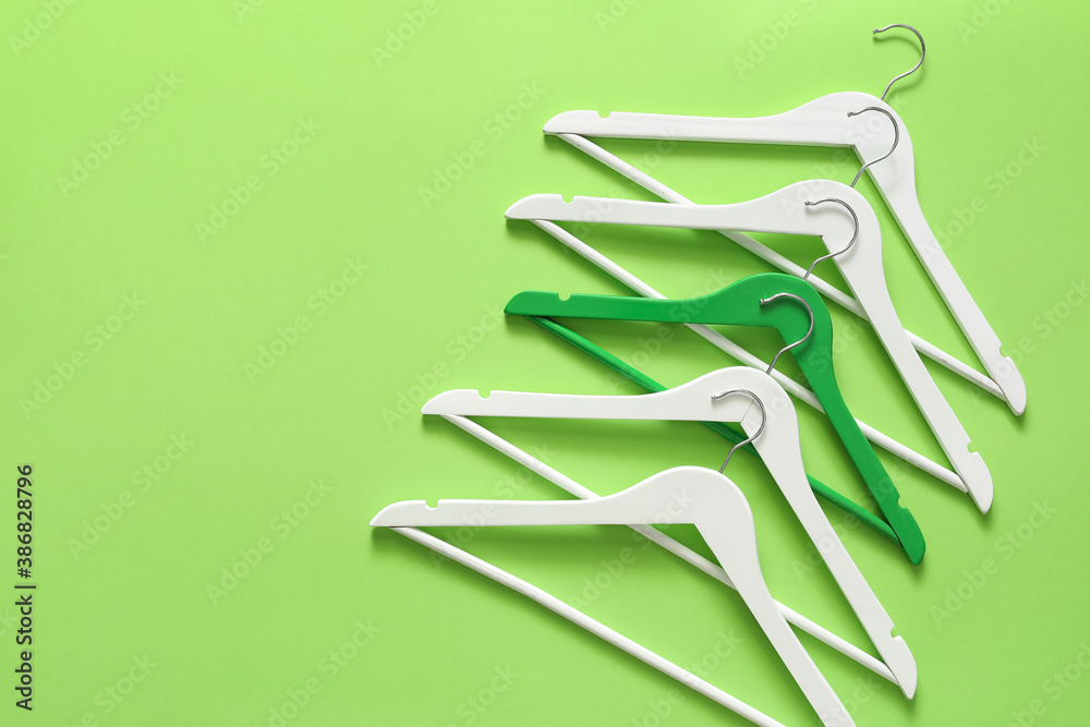 Clothes hangers on color background