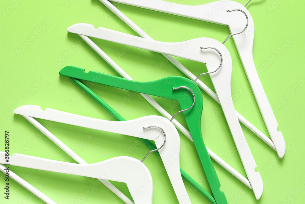 Clothes hangers on color background