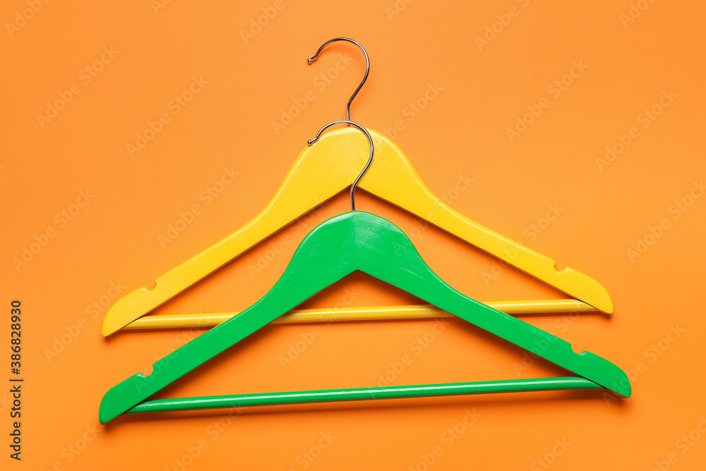 Clothes hangers on color background