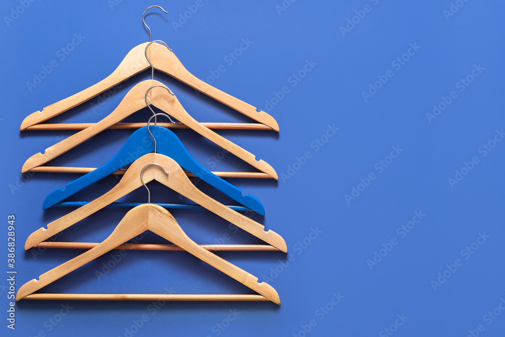 Clothes hangers on color background