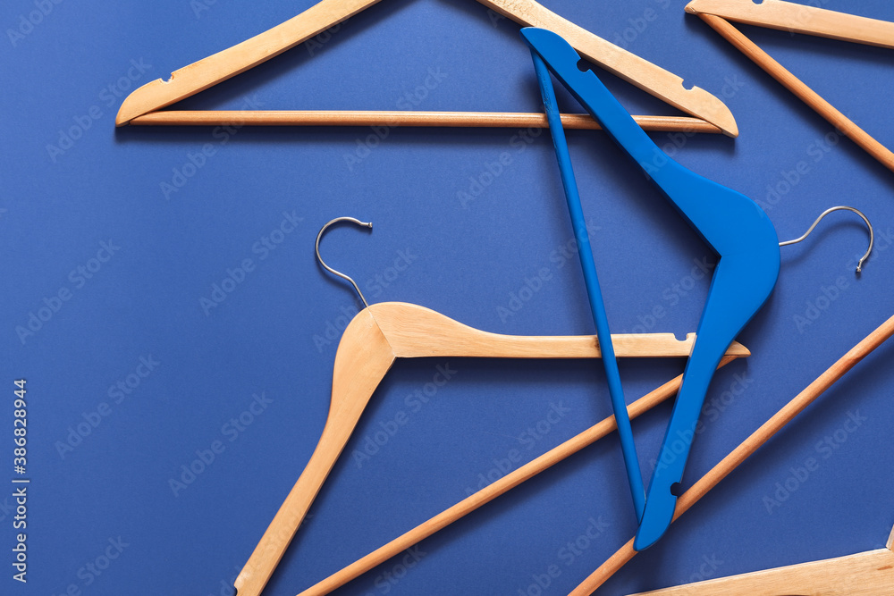 Clothes hangers on color background