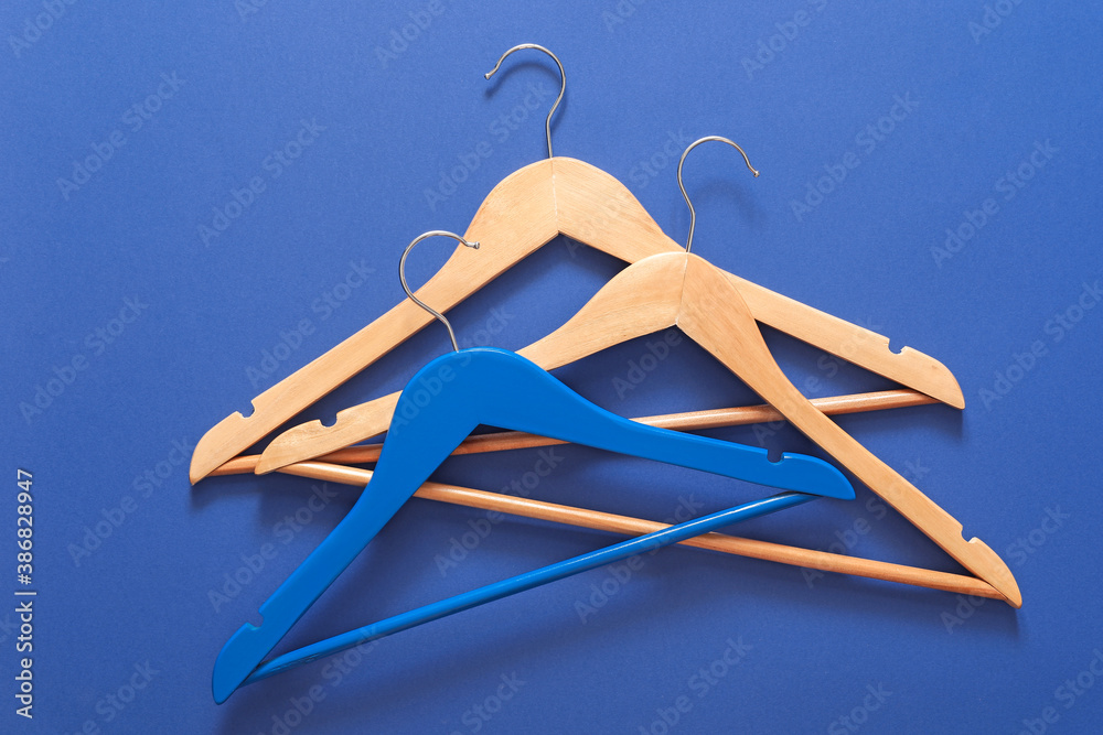 Clothes hangers on color background