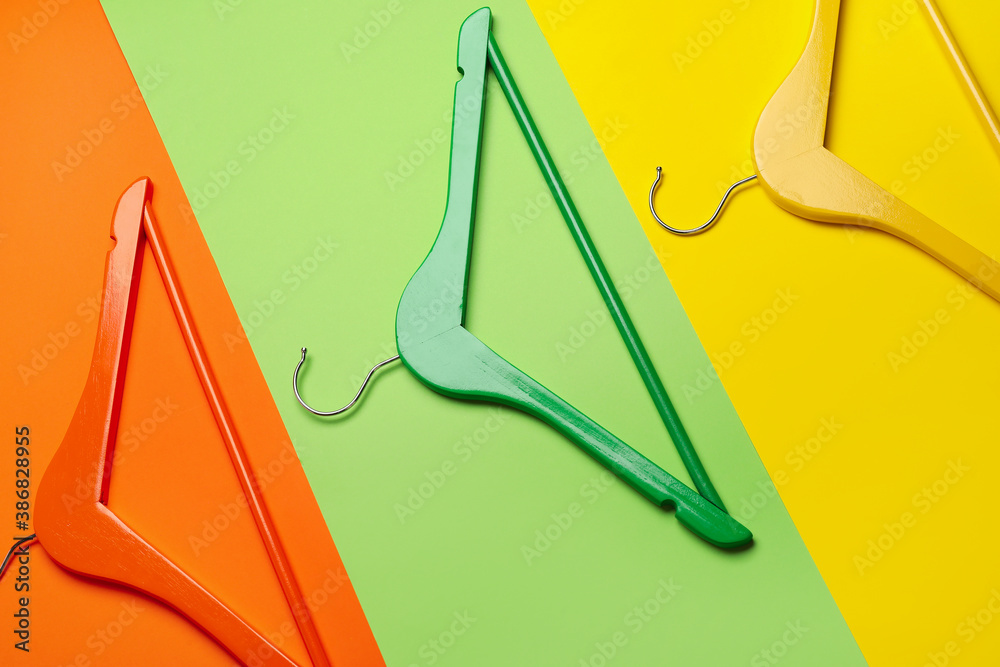 Clothes hangers on color background