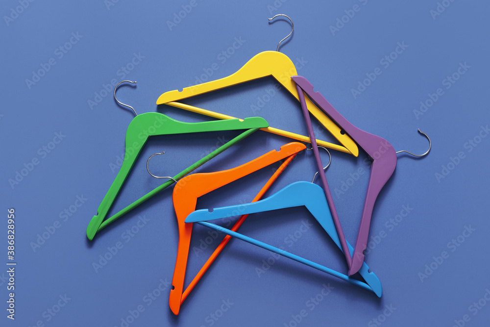 Clothes hangers on color background