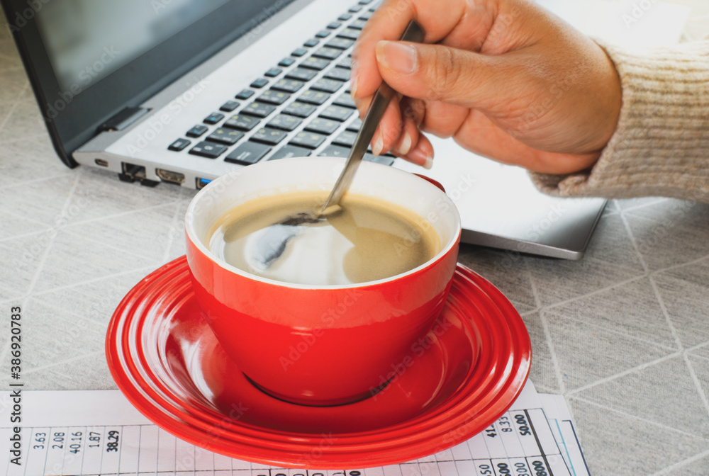 Starting the morning in working day with A red cup of coffee and laptop, modern working lifestyle