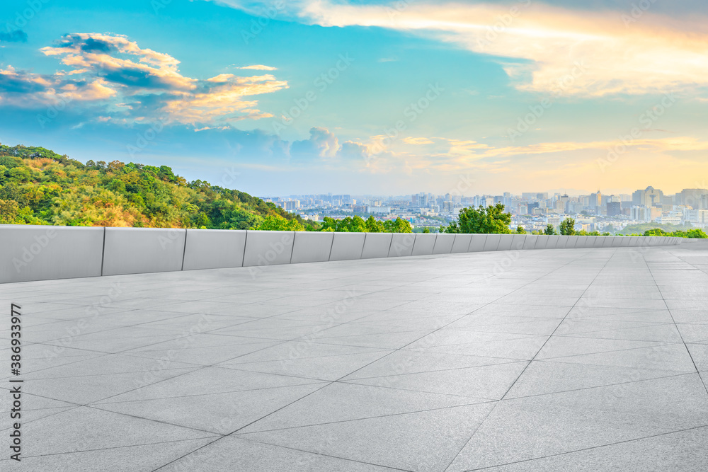 Empty square floor and city skyline with buildings in Hangzhou at sunrise.