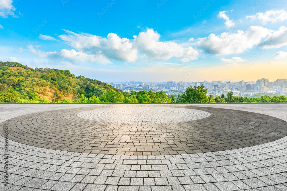 Empty square floor and city skyline with buildings in Hangzhou at sunrise.