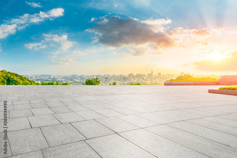 Empty square floor and city skyline with buildings in Hangzhou at sunrise.