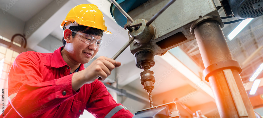 Asian man foreman working with drill press machinery with safety uniform concept smart manufacturing