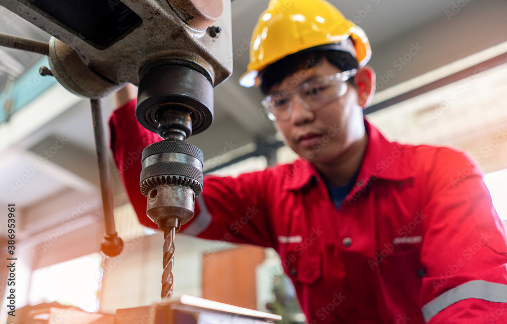 Asian man foreman working with drill press machinery with safety uniform concept smart manufacturing