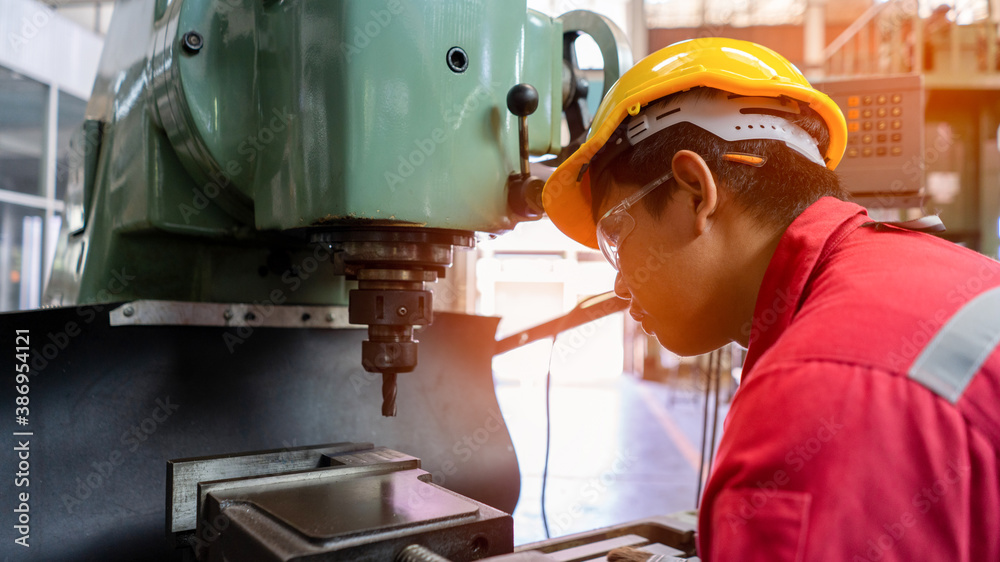 Asian man foreman working with NC Lathe machinery with safety uniform concept smart manufacturing in