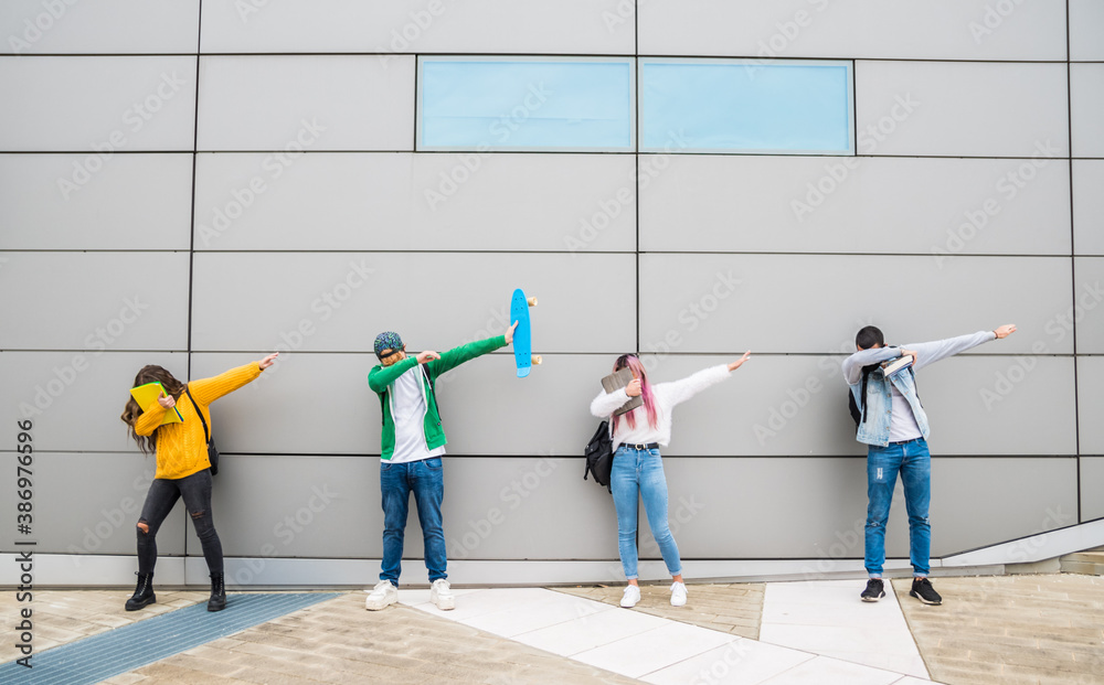 Funny young friends in casual clothes dancing dub dance on grey wall background.