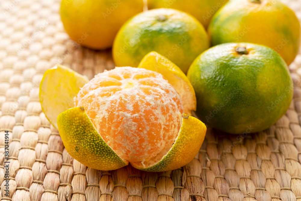 Premature tangerines on an Asian luncheon mat