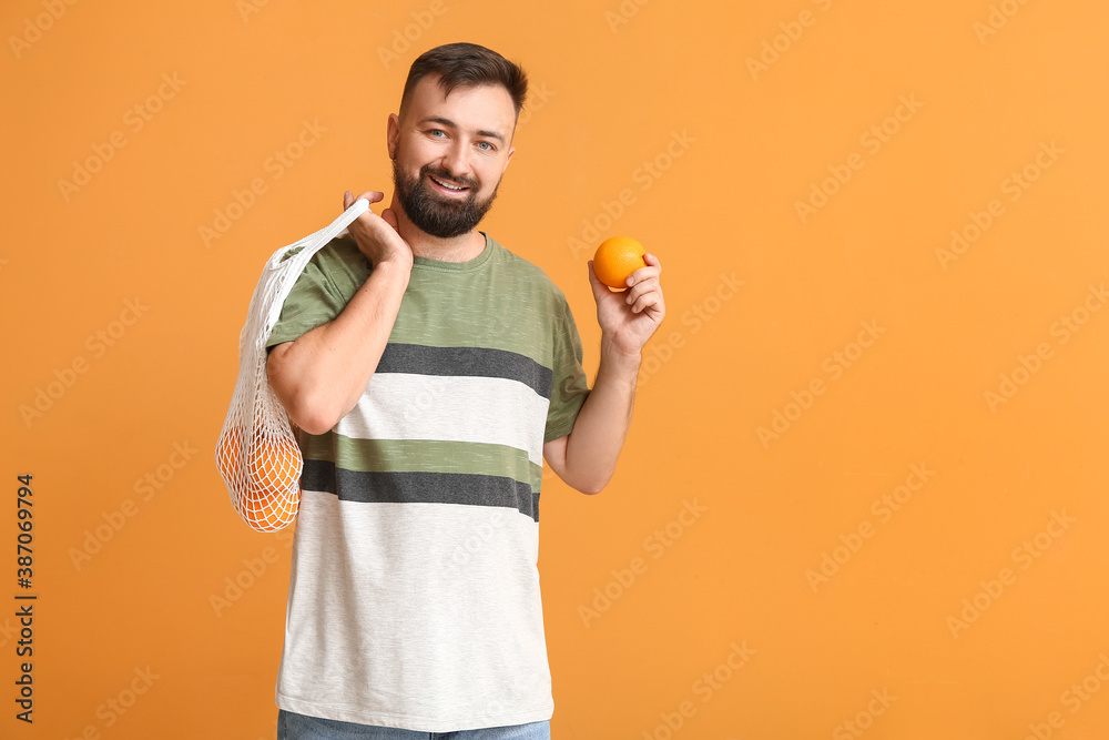 Man with oranges on color background