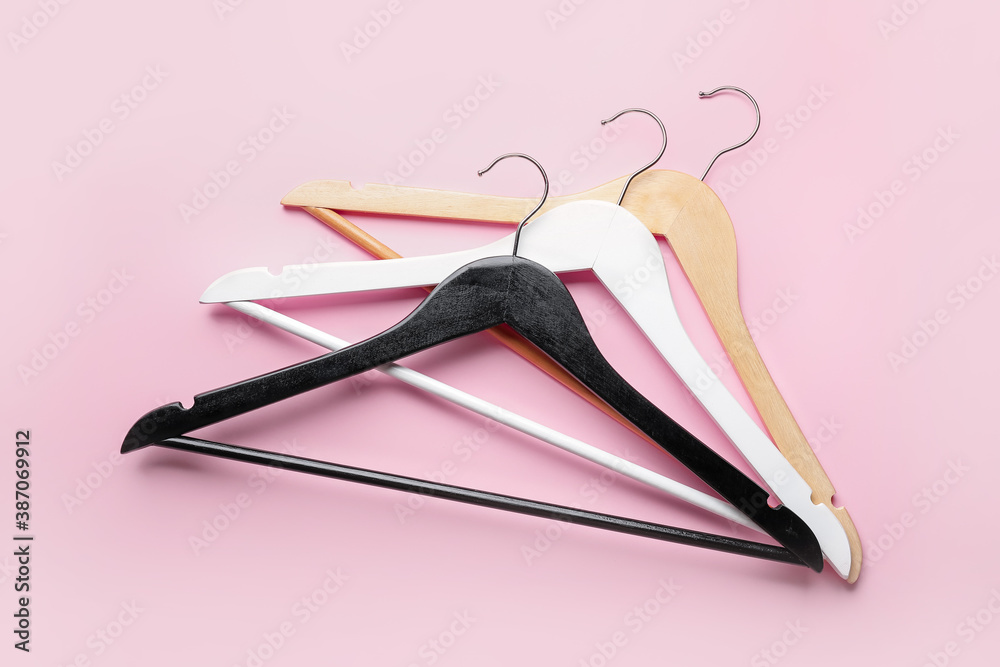 Clothes hangers on color background