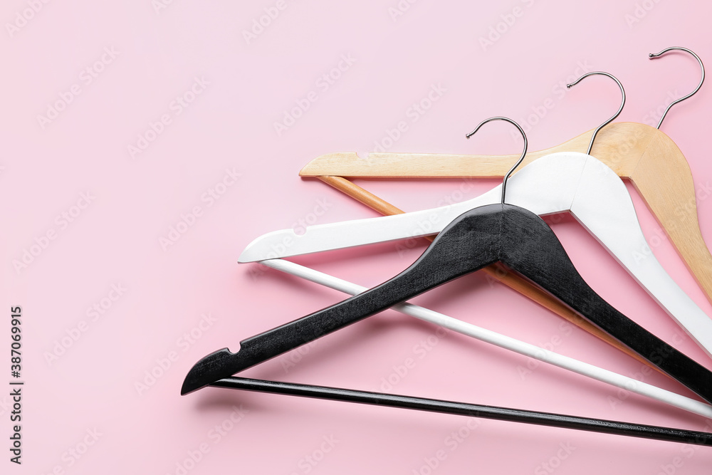 Clothes hangers on color background