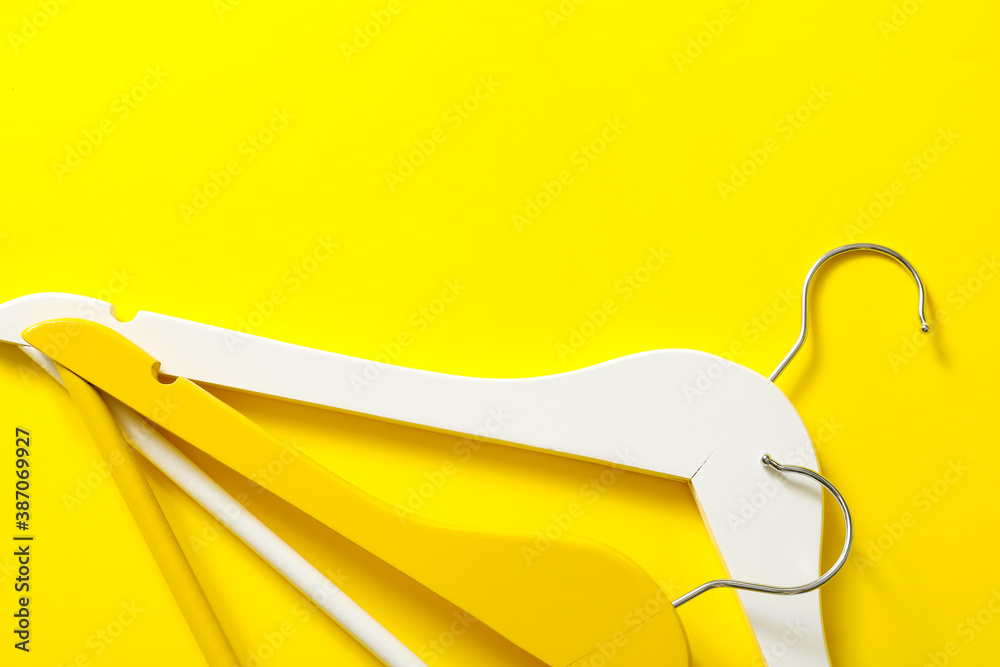 Clothes hangers on color background